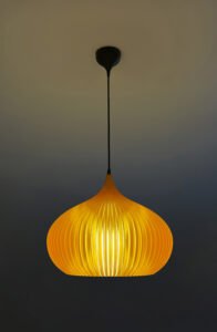 Person adjusting amber lampshade indoors