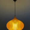 Person adjusting amber lampshade indoors