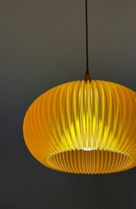 warm amber pendant light shade with pleated design illuminated