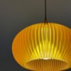 warm amber pendant light shade with pleated design illuminated