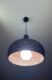 Black 3D printed pendant light glowing with warm copper interior, UMBRA design by 3Dcor