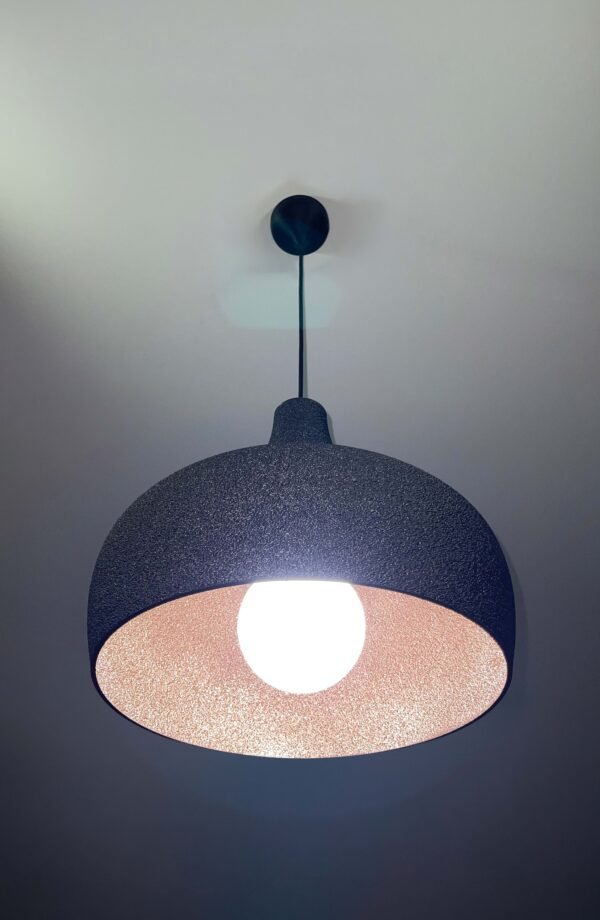 Black 3D printed pendant light glowing with warm copper interior, UMBRA design by 3Dcor