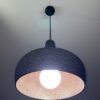 Black 3D printed pendant light glowing with warm copper interior, UMBRA design by 3Dcor